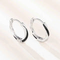 Silver hoop earrings - geometric rhodium plated design in white gold color on model