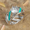 Silver engagement ring with round crystal prong setting and turquoise inlays on geometric band