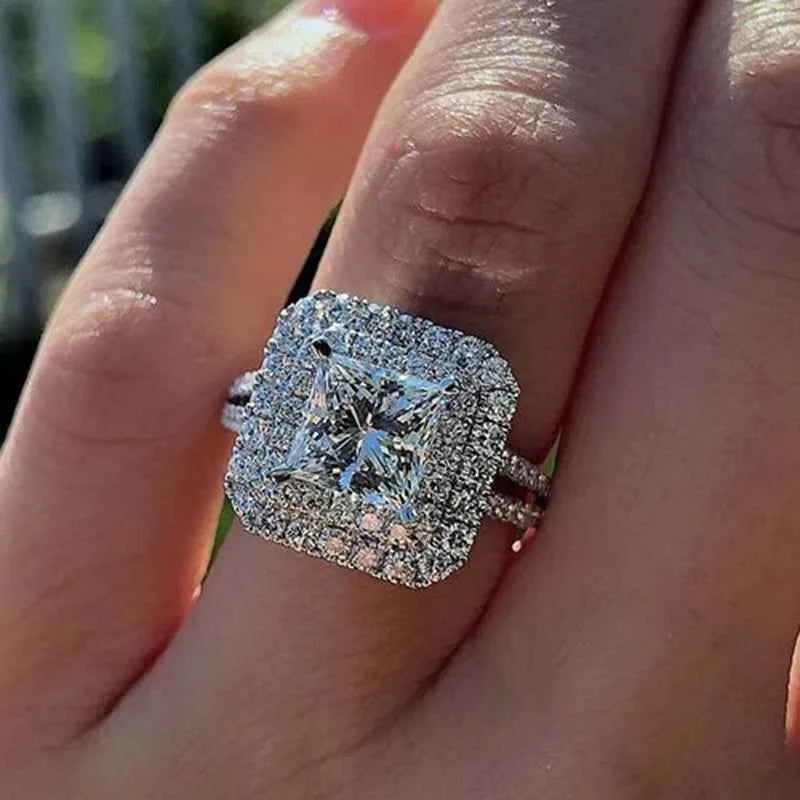 Princess cut diamond ring - square halo setting with brilliant center stone on white background