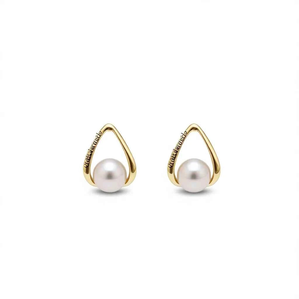 Bezel set pearl earrings - round white Akoya pearls in geometric gold bezel on display