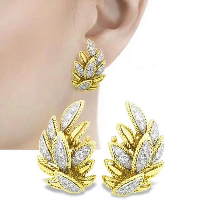 Gold leaf stud earrings with marquise diamond prong setting in polished gold finish