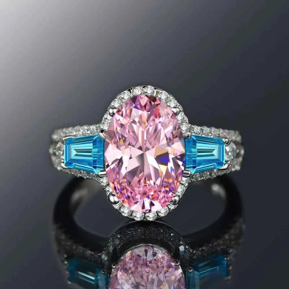 Platinum pink tourmaline ring - oval cut pink gemstone with diamond halo and blue side stones on white background