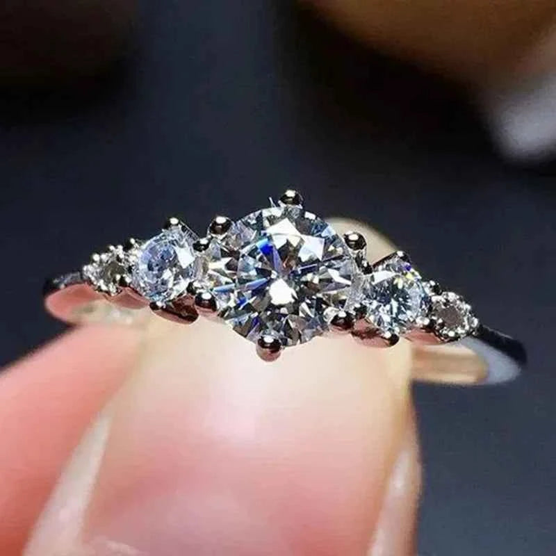 Classic engagement ring - round brilliant cut diamond with side diamonds on polished band