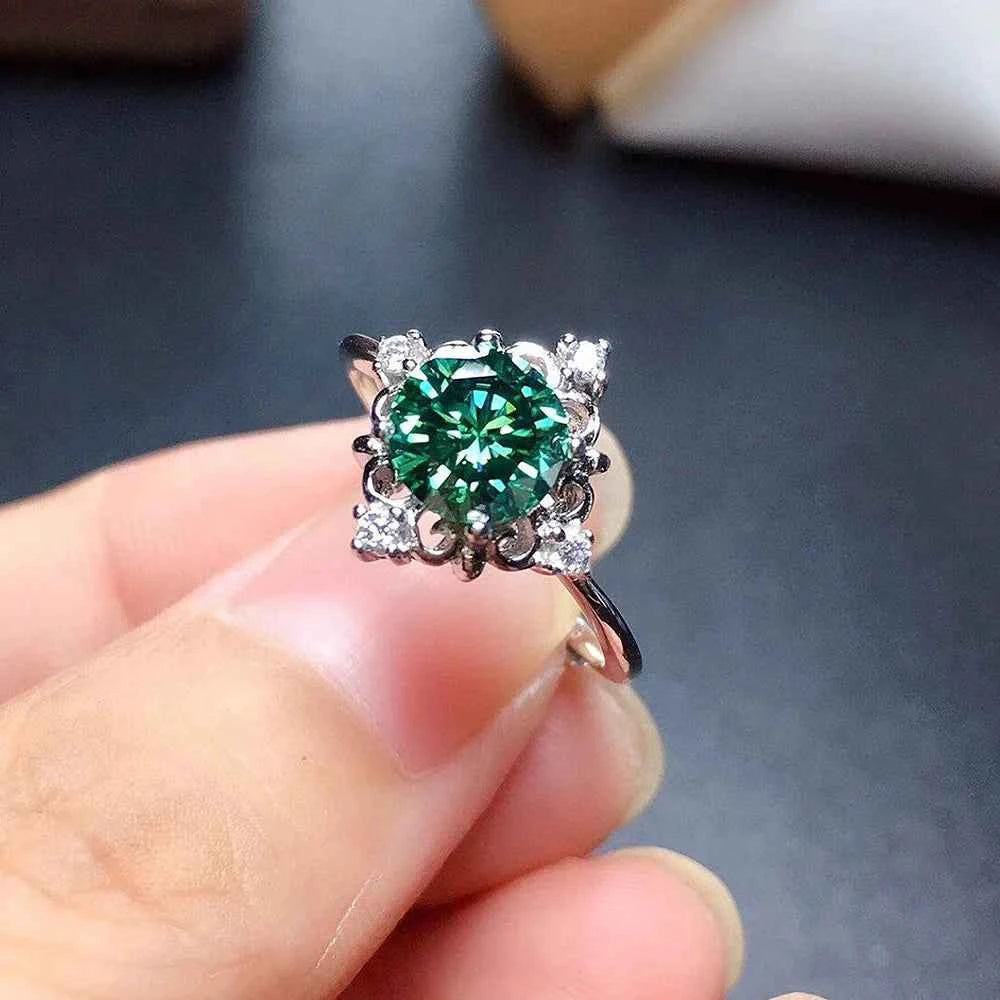 Natural emerald ring - round green gemstone with halo setting and floral prong design on finger