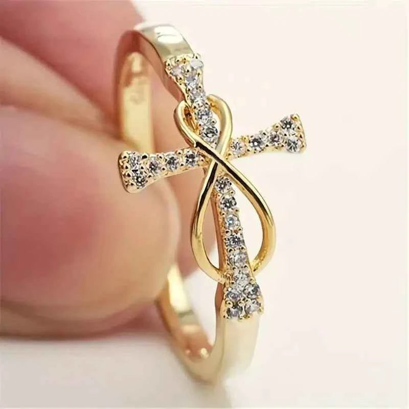 Cross infinity ring - elegant yellow gold with brilliant cut diamond on white background