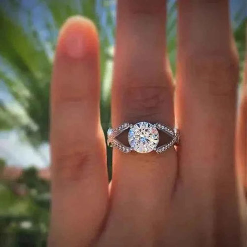 Diamond engagement ring - round-cut center stone with pavé-set accent diamonds on split-shank band