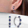 White gold hoop earrings with brilliant-cut zircon - classic style for women with claw setting on white background