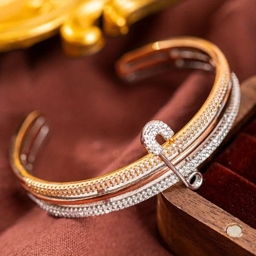 Elegant copper bangle bracelet - unique safety pin design on a woman's wrist