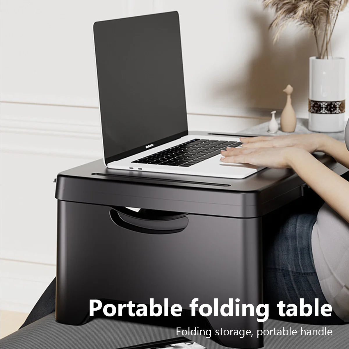 Foldable laptop desk - black plastic portable working table on a bed